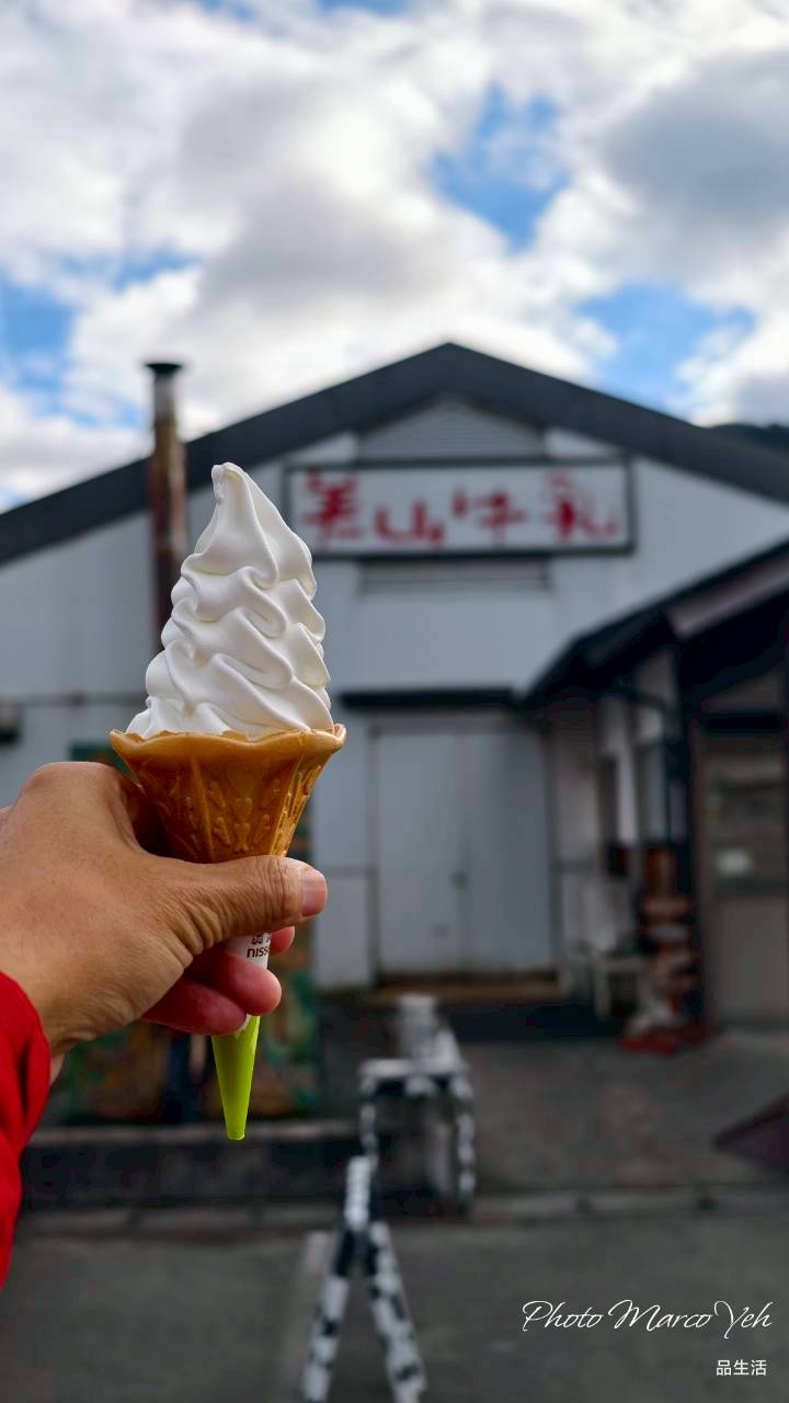 手持牛乳冰淇淋,背景是美山牛乳工房