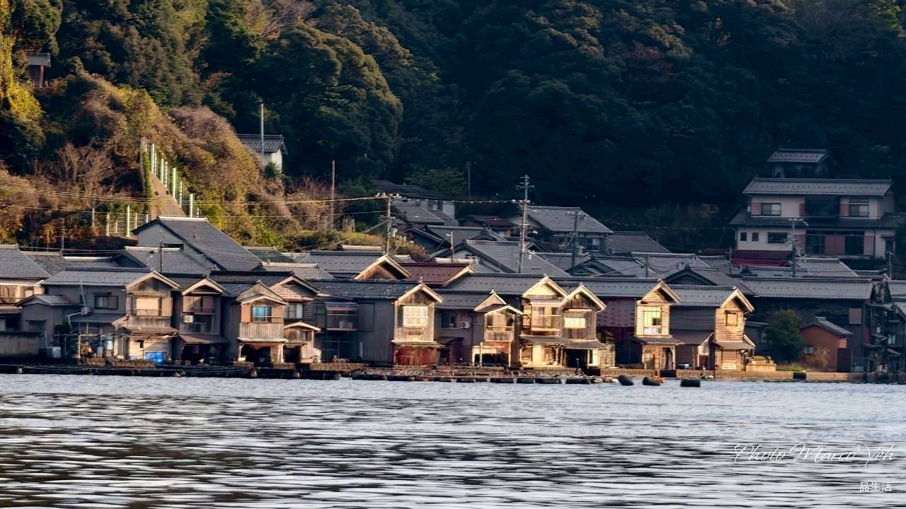 伊根灣水面前,一排木造舟屋沿岸而立